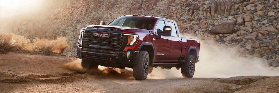 A Red GMC Sierra HD AT4X AEV Driving Off-Road