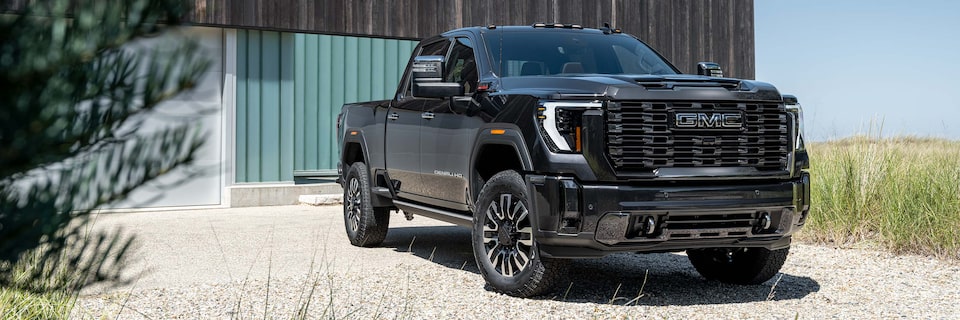 Wide Front Three-Quarters View of a GMC Denali Truck Parked on Gravel in Front of a Home