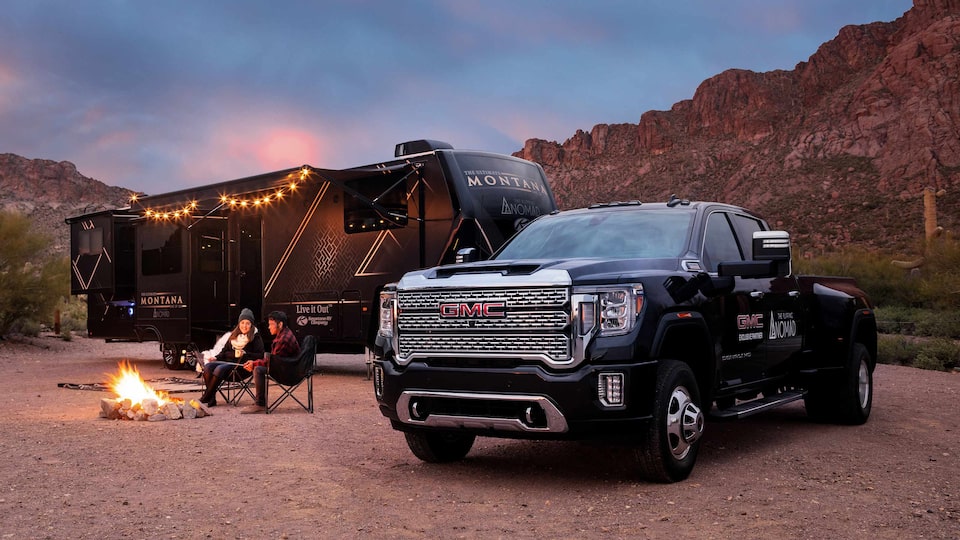 GMC Sierra 3500 HD Denali parked in front of a camping RV