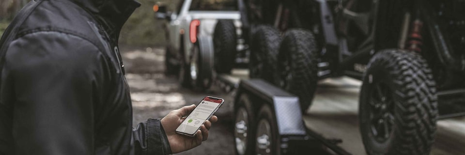 Man using his myGMC App to use the GMC Smart Trailer feature