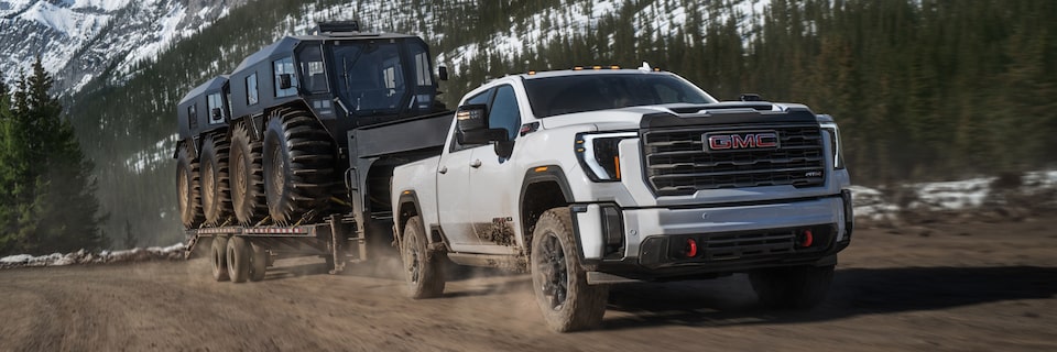 Front Three-Quarters View of a GMC Truck Pulling a Trailer Loaded with Two Big Centaur UTVs