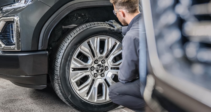 GMC Certified Service technician rotating a vehicle’s tires