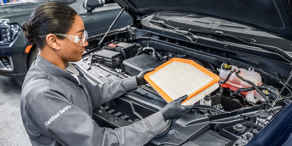 GMC Certified Service Technician Installing an Engine Air Filter in a Vehicle