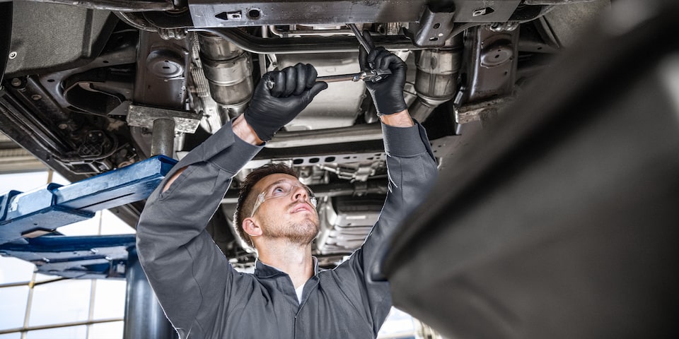 GMC Certified Service Technician Working Underneath a Vehicle