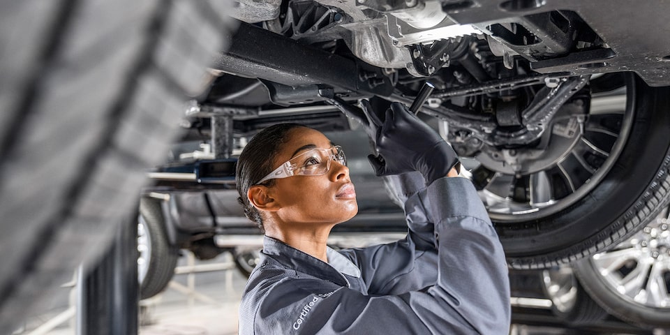 GMC Certified Service Technician Inspecting Underneath Vehicle