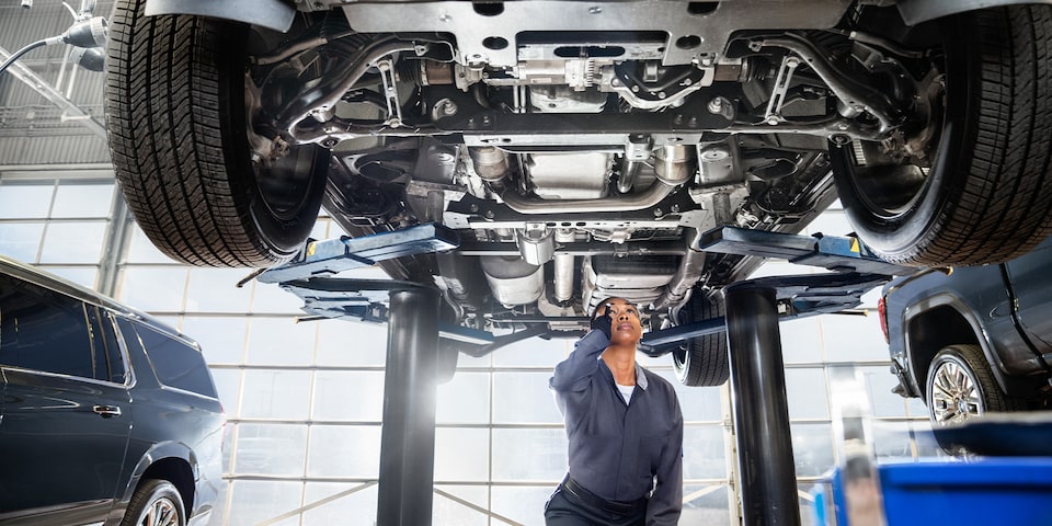 GMC Certified Service Technician Inspecting Underneath Vehicle