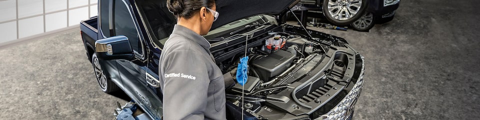 Two GMC Certified Service Technicians Working on a Vehicle