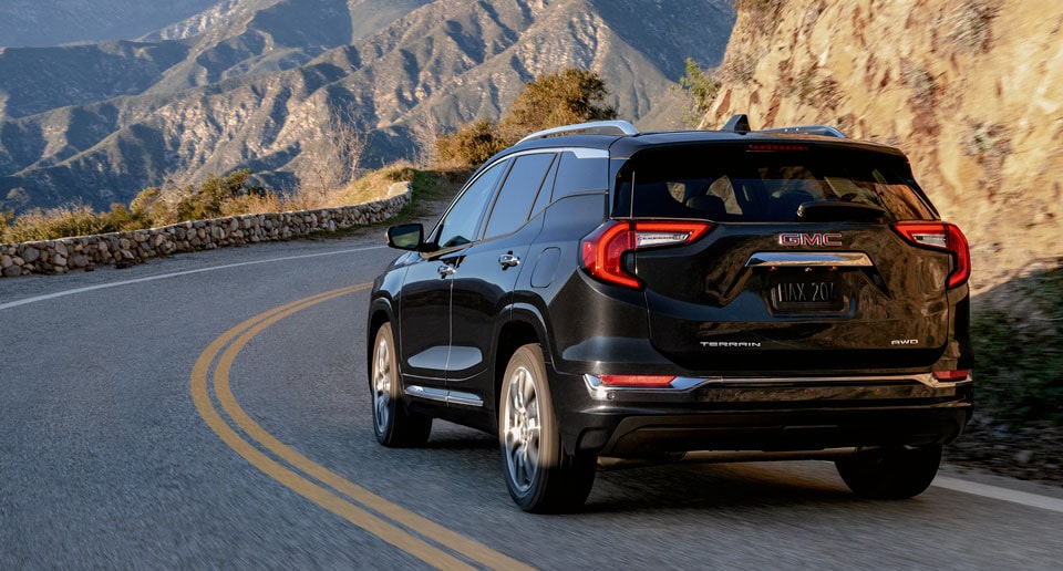 GMC SUV Driving Along Cliffside Road