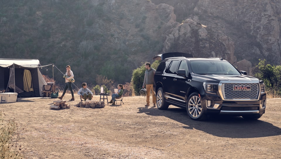 Family Setting Up Camping Tents Next to Their GMC Sierra Truck