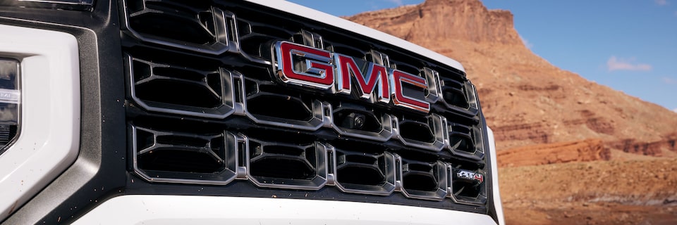 Close-up of the GMC Emblem on a GMC Canyon AT4 Truck With Mountains in the Background