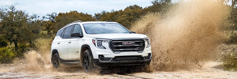 A GMC Terrain AT4 SUV Splashing Up Mud While Off-Roading