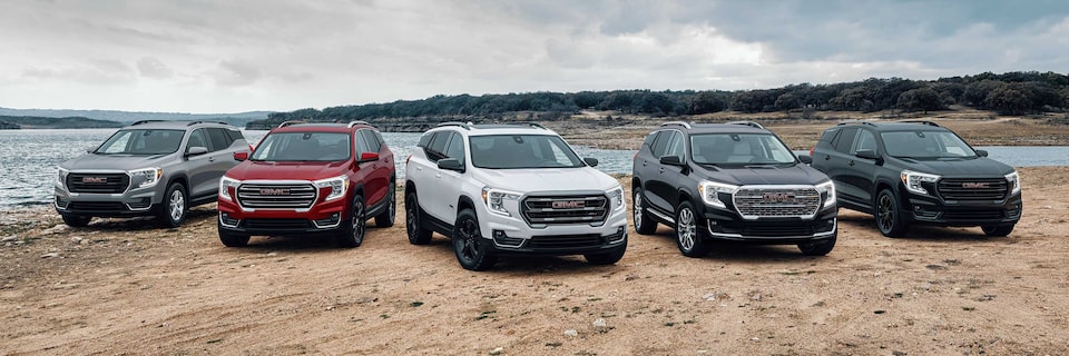 Line-up of GMC SUVs Parked Side by Side on a Sandy Path