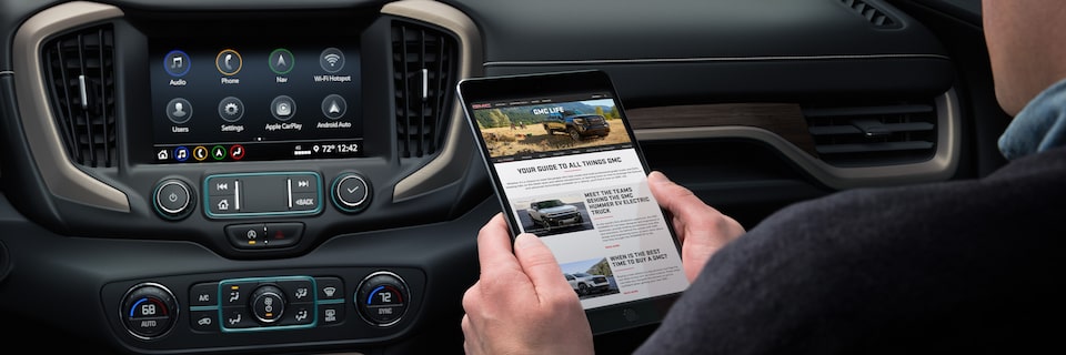 Close-up of a Person Sitting in a GMC Vehicle Using a Tablet