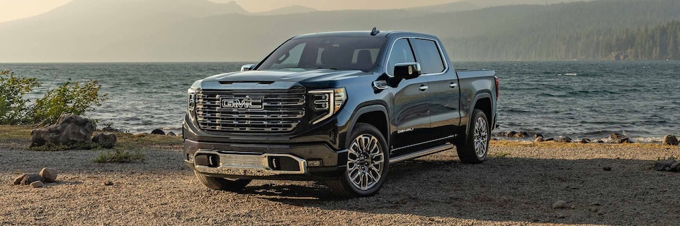 Wide Front Three-Quarters View of a GMC Sierra 1500 Denali Truck Parked in Front of the Ocean