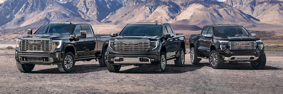 Lineup of GMC Trucks Parked Side by Side With Mountains in the Background