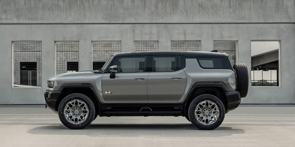 Side View of a Gray GMC Hummer EV SUV Next to a Building