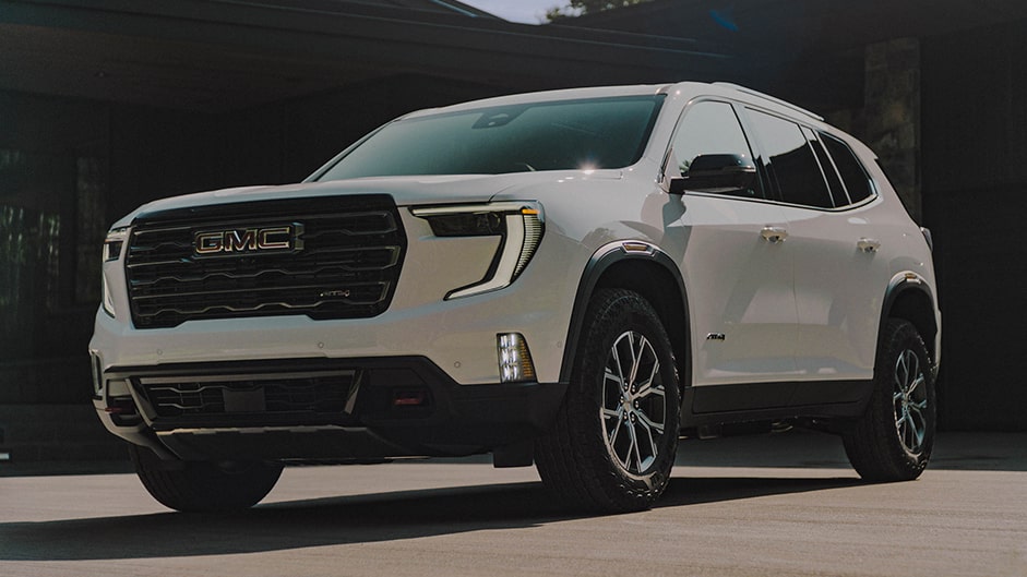 Close-up Front Three-Quarters View of a 2024 GMC Acadia Parked In Front of a Building