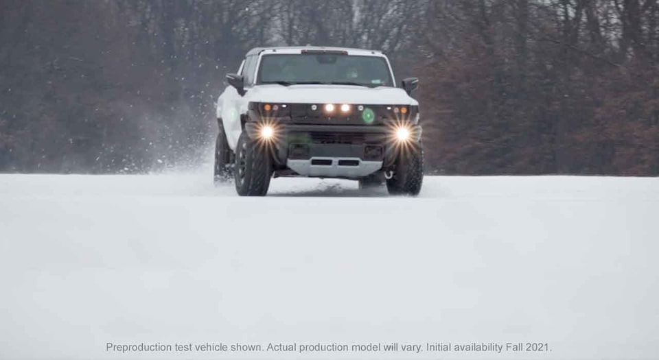 GMC HUMMER EV electric truck driving in the snow