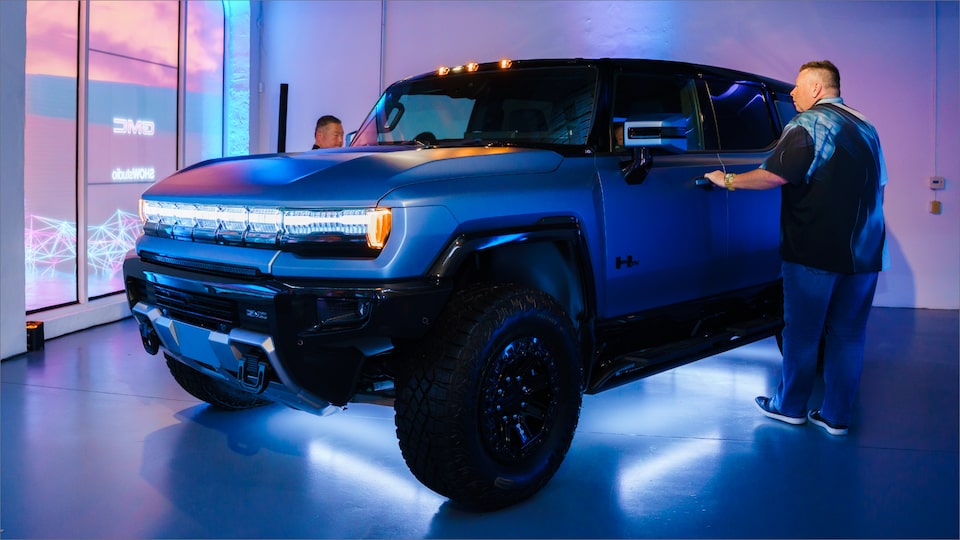 A Man about to Open the Driver's Side Door of the GMC HUMMER EV