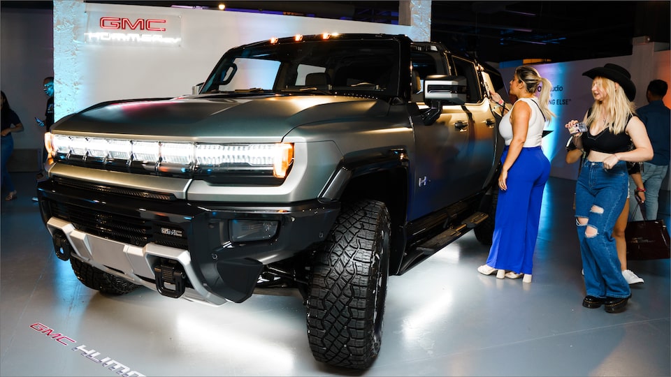 Two Woman Checking out the Driver's Side of the GMC HUMMER EV