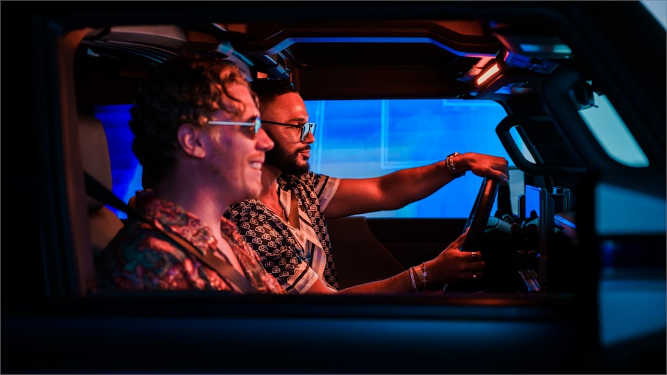 A Side Profile View of Two Men Sitting in a GMC HUMMER EV