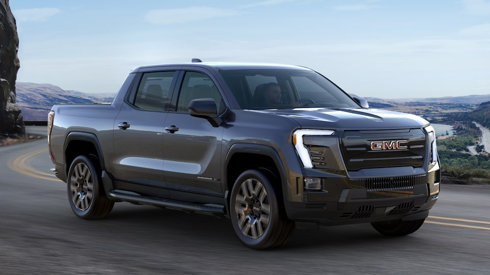 Front Three-Quarter View of a GMC Sierra EV Elevation Truck Parked In Front of a Business