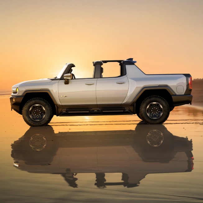 A Side Profile view of the GMC HUMMER EV Pickup Truck with a Sunset