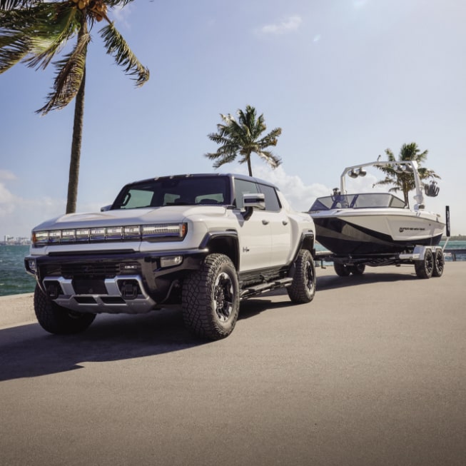 The GMC HUMMER EV Pickup Truck Towing a Boat