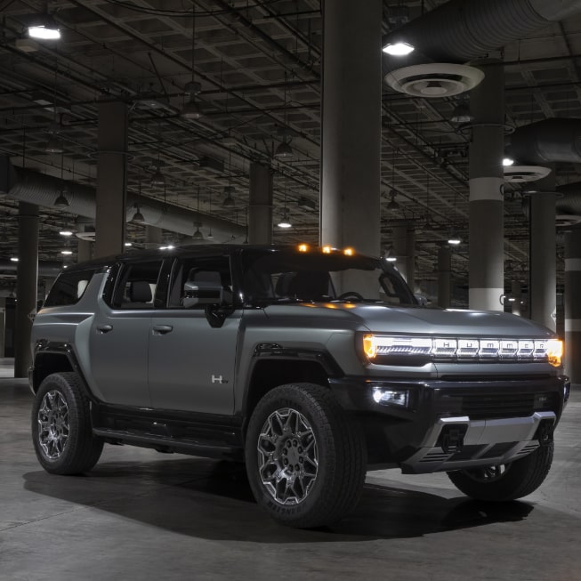 The GMC HUMMER EV SUV Driving Off-Road through Mud and Water