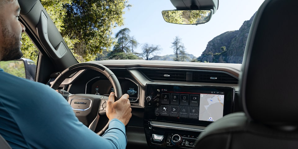 View From Rear Seating of a  Man Driving a GMC Vehicle