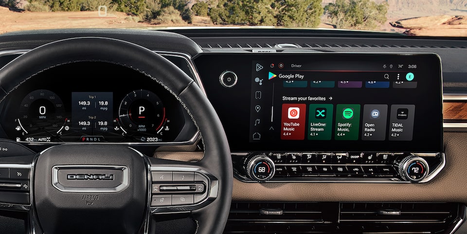 Close-up of the Steering Wheel and Infotainment System with Entertainment Options in a GMC Vehicle