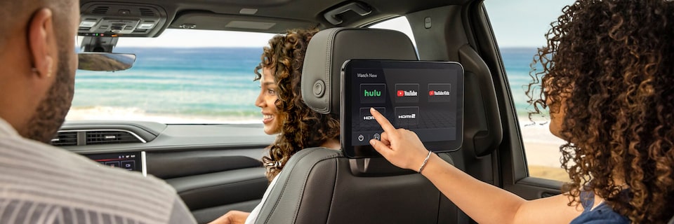 Birds-eye View of Two People Sitting in a Vehicle With One Driving and the Other Using a Tablet