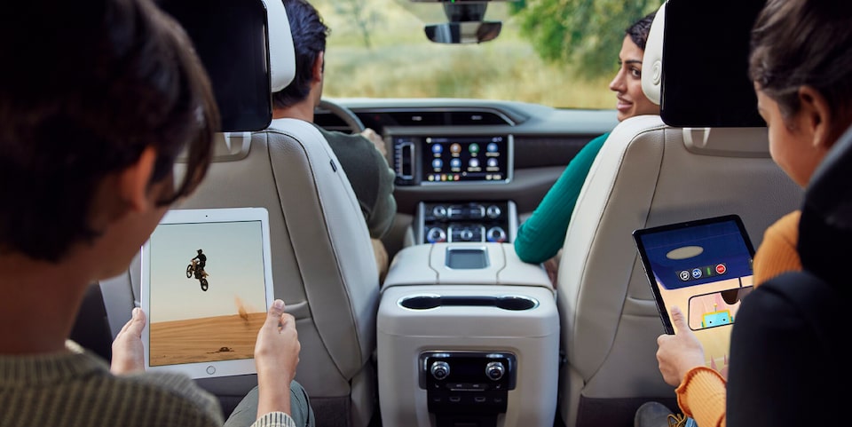 A Family in a GMC Vehicle With Children in Rear Seats Using Tablets