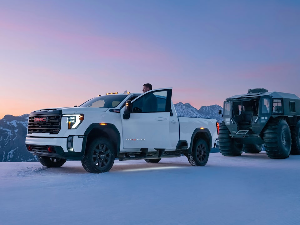 A Man Getting Out of His GMC Truck to Watch the Sunrise Over a Snowy Mountain