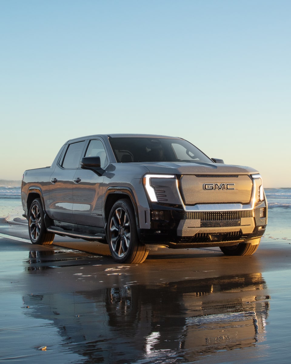 Front Three Quarters View of the GMC Sierra EV Denali Edition 1 Truck Parked on a Beach