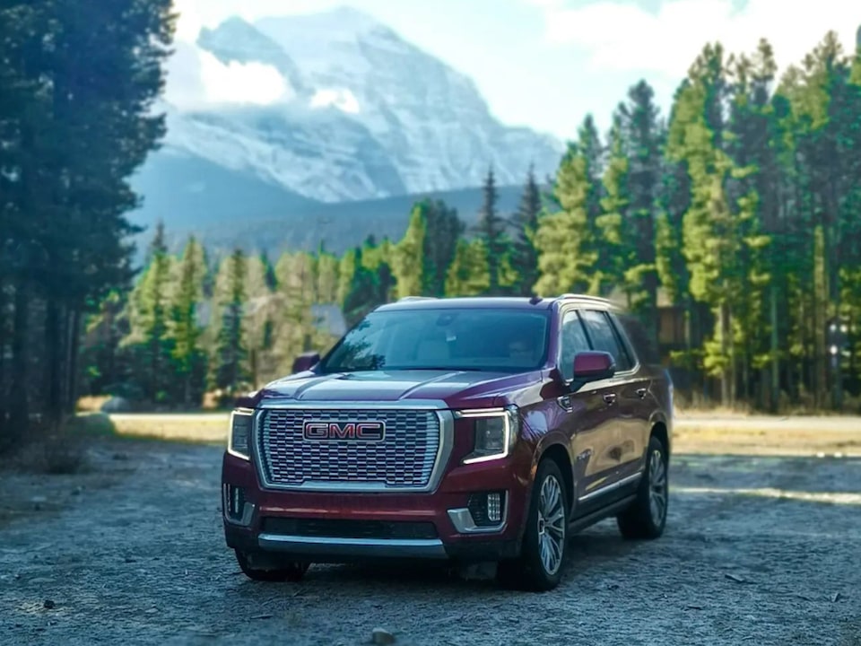 Front Three-Quarters View of a GMC Yukon SUV Parked in a Forest