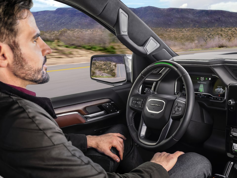 A Man Sitting in the Driver's Seat of a Vehicle Using the Super Cruise Feature