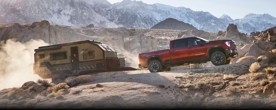 The GMC Sierra HD Driving Off-Road Towing a Trailer