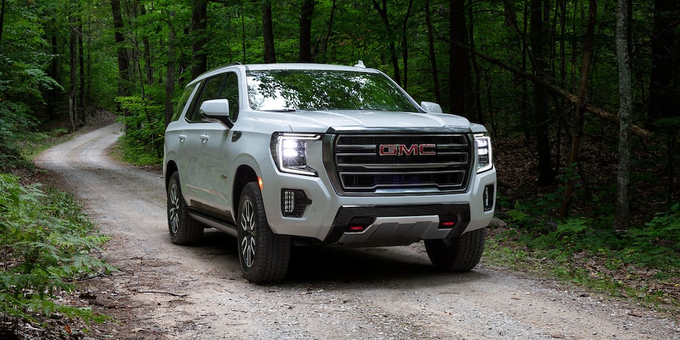 A White GMC Yukon Driving Off-Road through the Forest