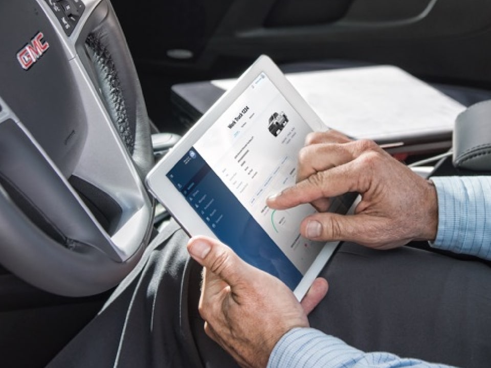 A Person Sitting in a GMC Vehicle Using the Connected Services App