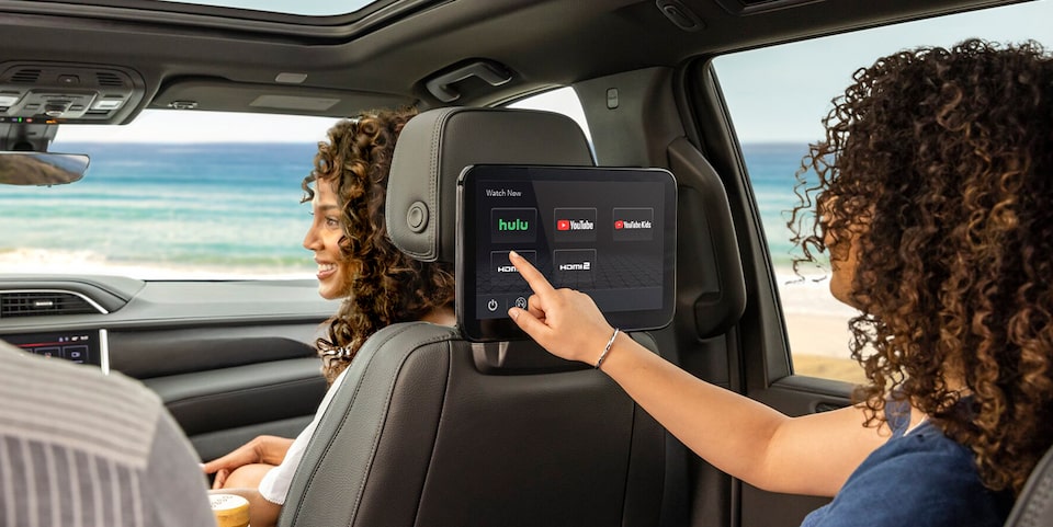 Birds-eye View of Two People Sitting in a Vehicle With One Driving and the Other Using a Tablet