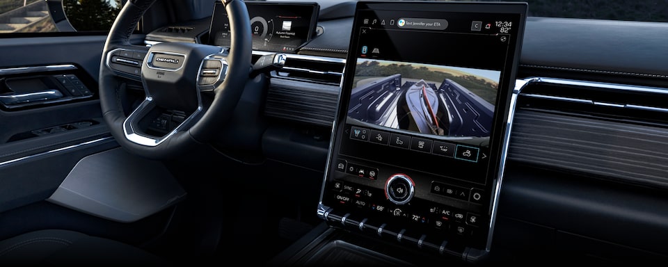 Interior View of the GMC Sierra EV's Steering Wheel and Infotainment System With the Truck Bed Camera in Use