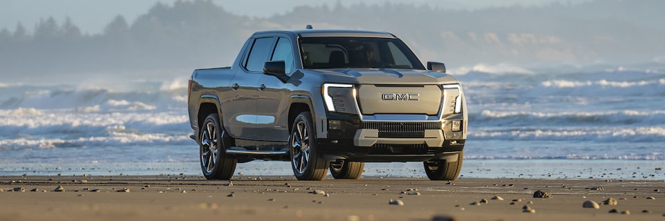 2025 GMC Sierra EV Pickup Truck Parked on the Beach with White Caps on the Water